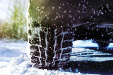 Car with winter tires on snowy road, closeup view