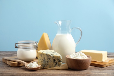 Different dairy products on wooden table against blue background