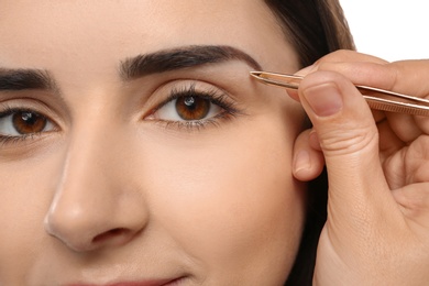 Young woman having professional eyebrow correction procedure, closeup