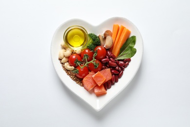 Photo of Plate with products for heart-healthy diet on white background, top view
