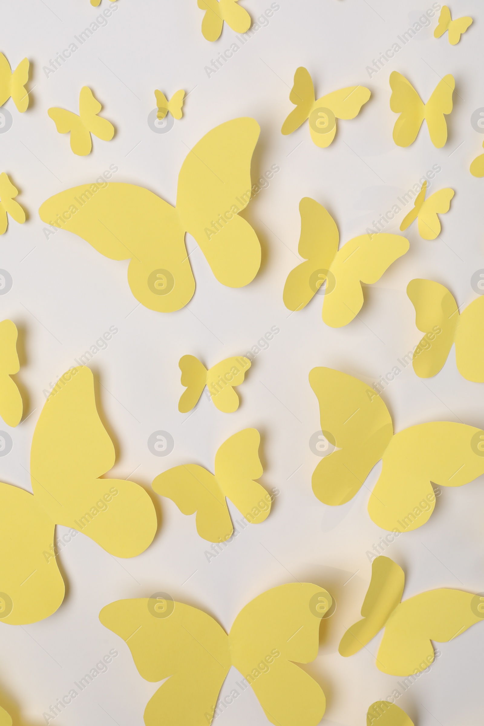 Photo of Yellow paper butterflies on white background, top view