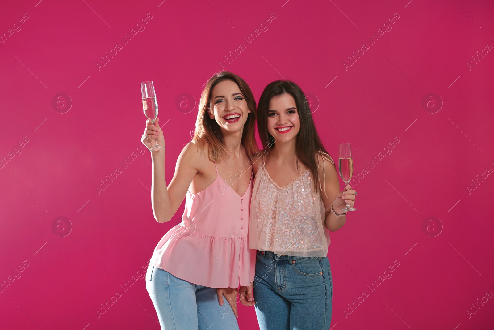 Photo of Portrait of happy friends with champagne in glasses on color background