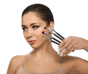 Photo of Beautiful woman with makeup brushes on white background