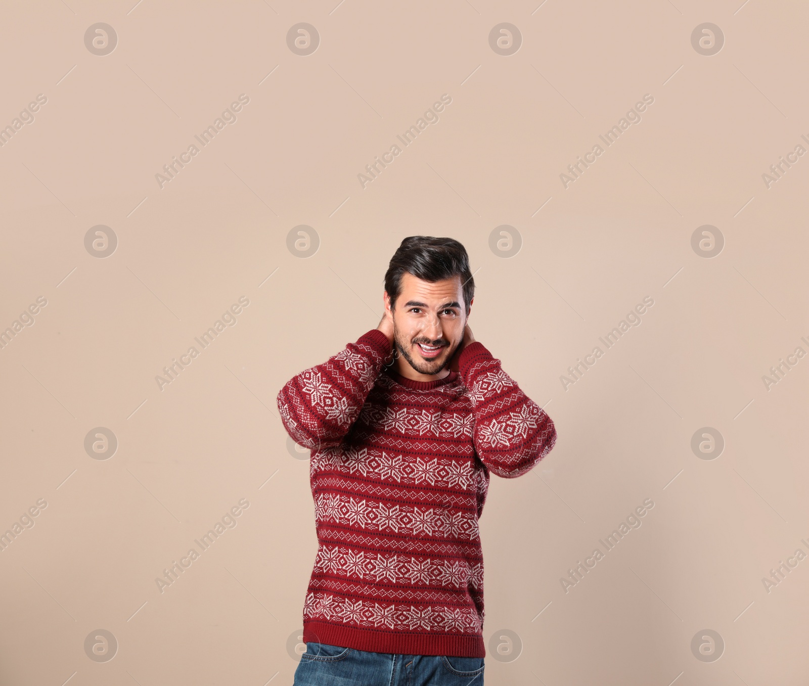 Photo of Portrait of happy man in Christmas sweater on beige background