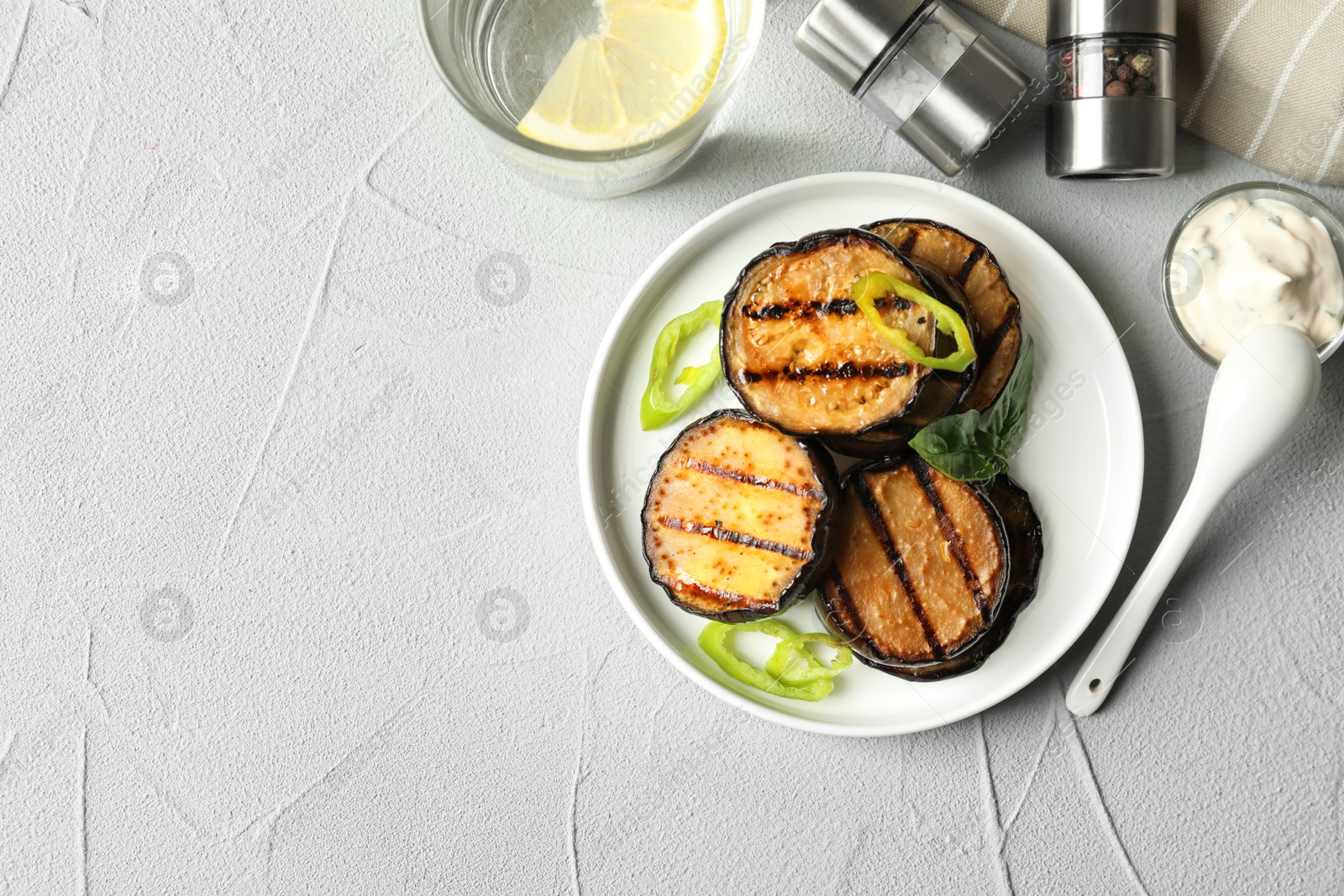 Photo of Plate with fried eggplant slices on table, top view. Space for text