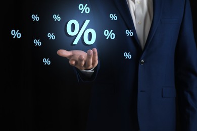 Image of Man showing virtual percent sign on black background, closeup. Discount concept