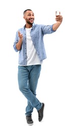 Photo of Smiling young man taking selfie with smartphone on white background