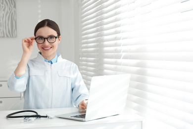 Photo of Portrait of young female doctor in white coat at workplace