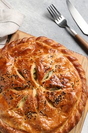 Photo of Tasty homemade pie served on light grey table, flat lay