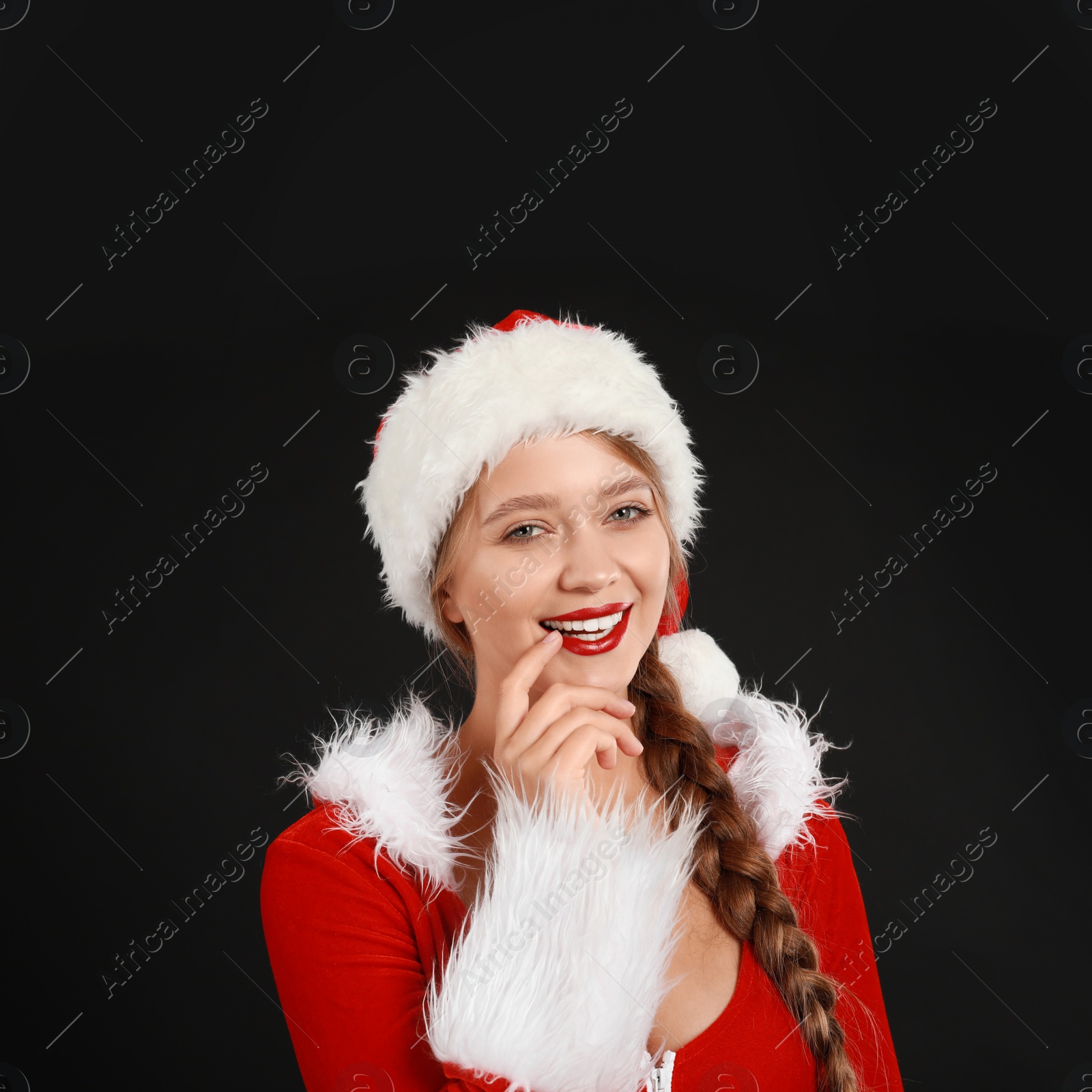 Photo of Beautiful Santa girl on black background. Christmas eve