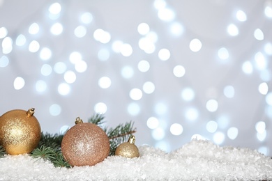 Photo of Christmas decoration on snow against blurred background, space for text