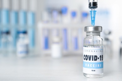 Photo of Filling syringe with vaccine against Covid-19 on white table