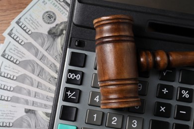 Photo of Tax law. Gavel, dollar banknotes and calculator on table, top view