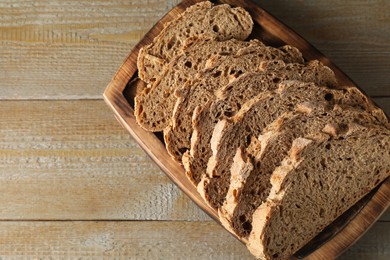 Photo of Freshly baked cut sourdough bread on wooden table, top view. Space for text