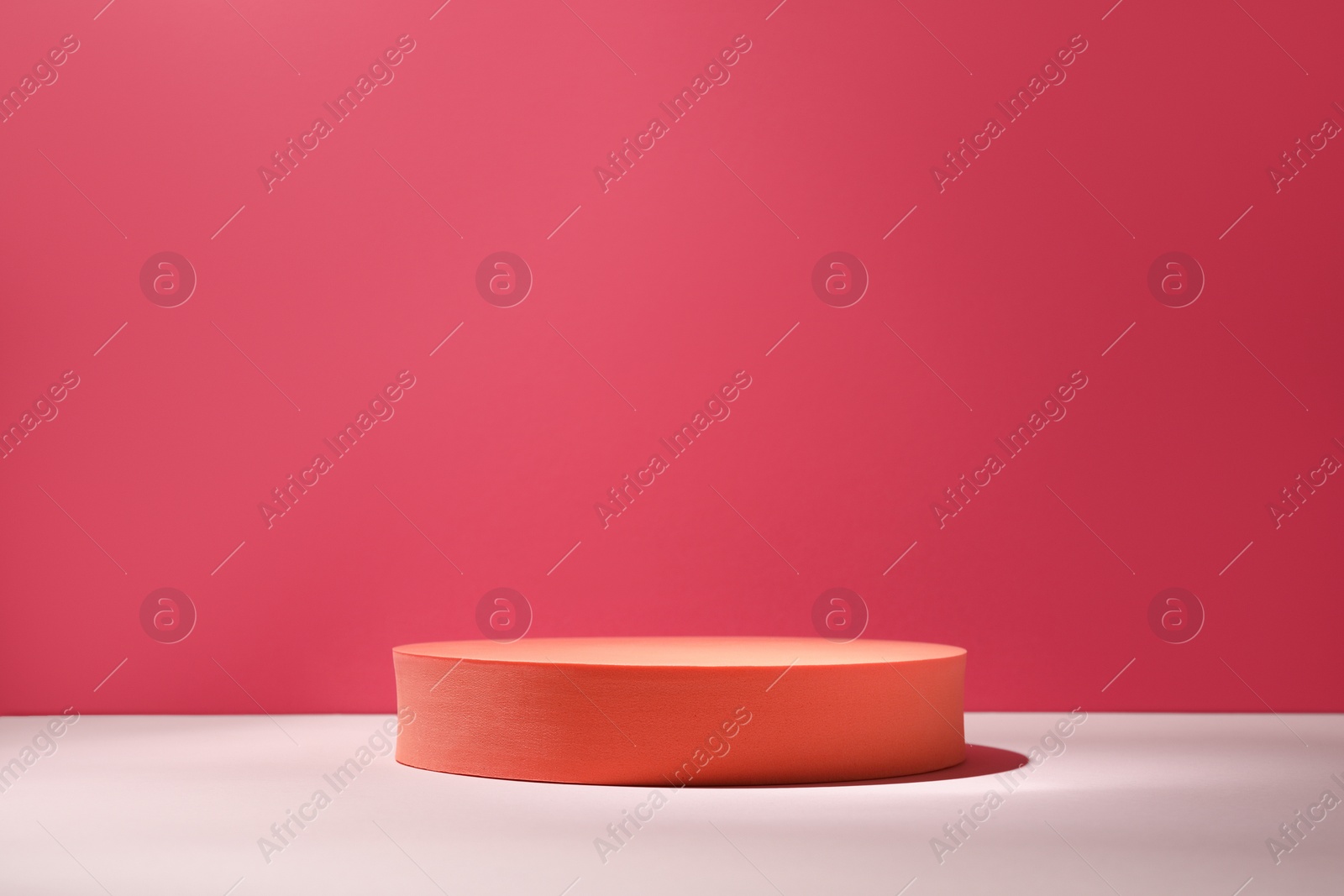 Photo of Orange stand on table against pink background, space for text. Stylish presentation for product