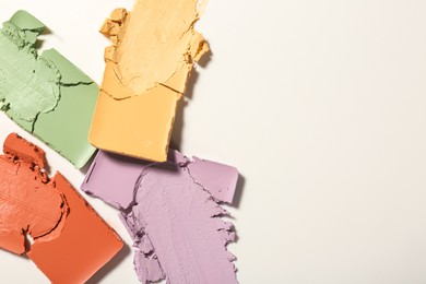 Samples of different color correcting concealers on white background