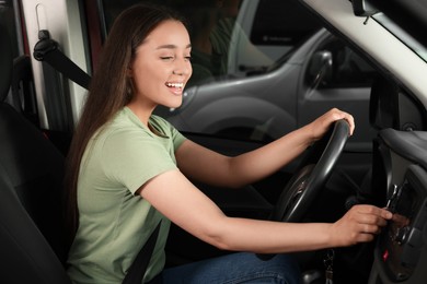 Choosing favorite radio. Beautiful woman pressing button on vehicle audio in car