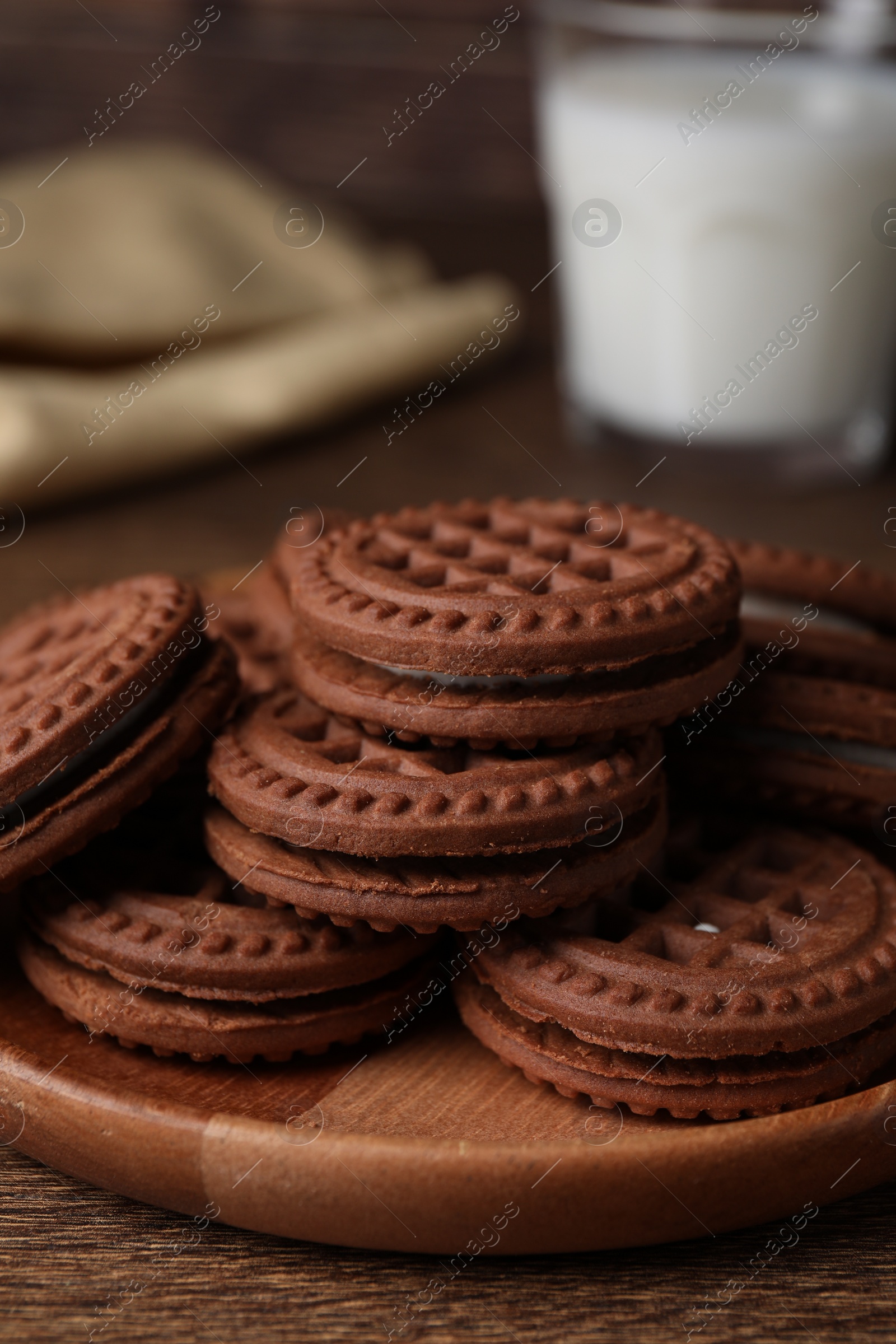 Photo of Tasty chocolate sandwich cookies with cream on wooden table, closeup