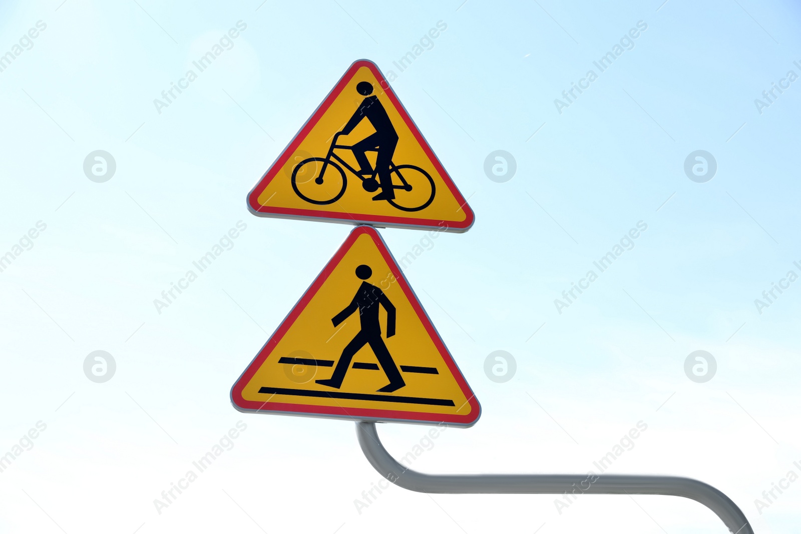 Photo of Signpost with cycle route and pedestrian crossing ahead against blue sky