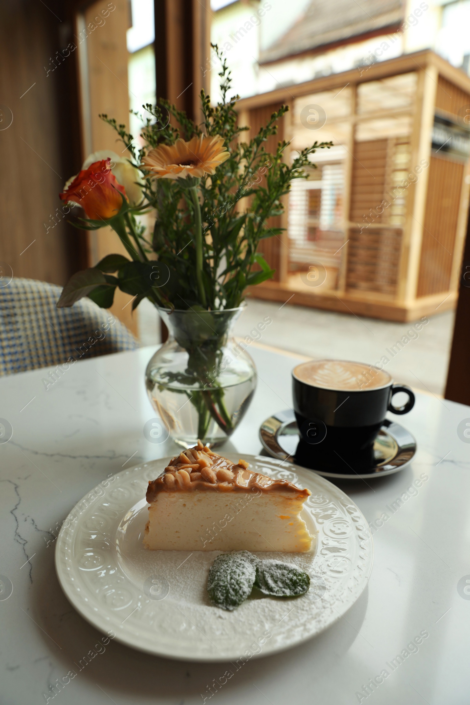 Photo of Tasty dessert and cup of fresh coffee on table in cafeteria