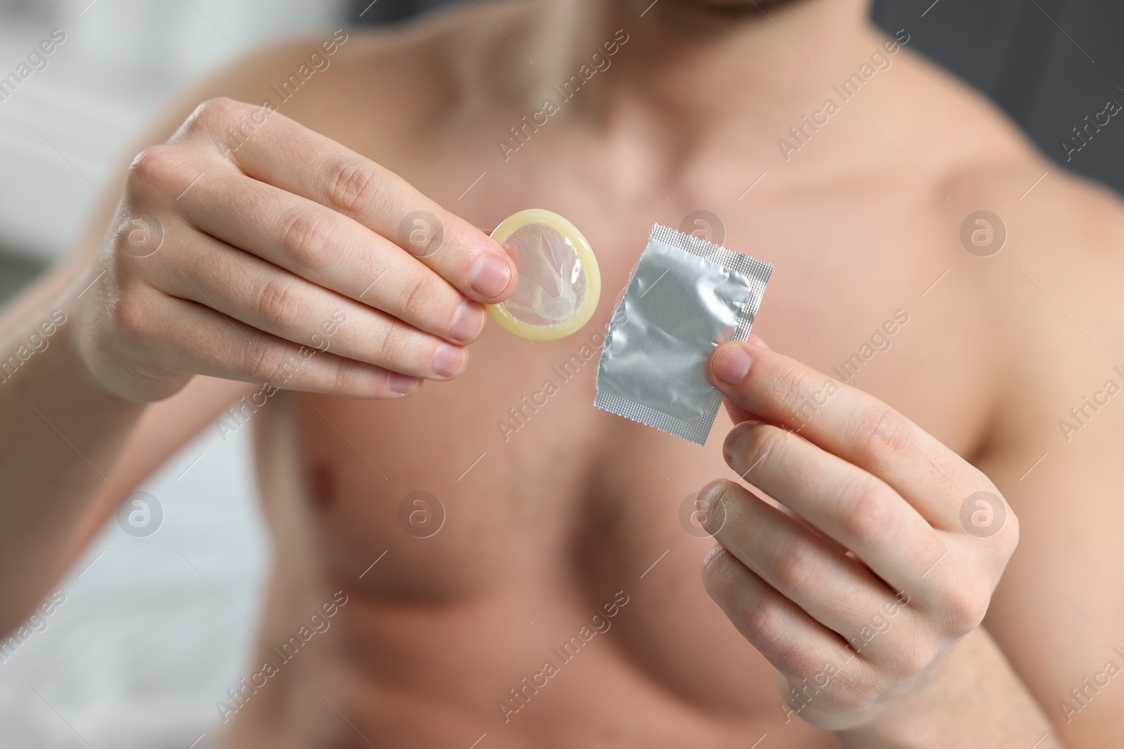 Photo of Closeup of man holding open pack and condom