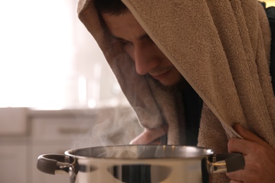 Man taking treatments indoors, closeup. Steam inhalation
