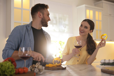 Lovely young couple cooking together in kitchen