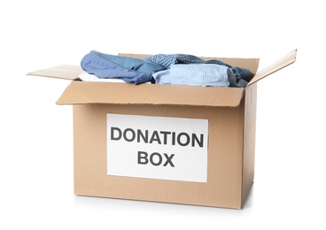 Photo of Donation box with clothes on white background