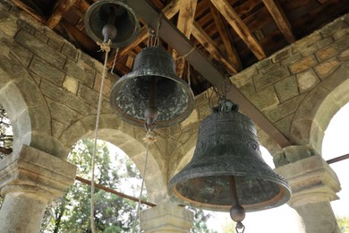 Photo of Low angle view of different old bells in tower