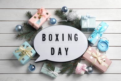 Photo of Flat lay composition with Boxing Day sign and Christmas gifts on white wooden table