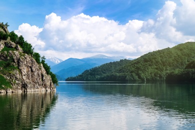 Photo of Picturesque view of beautiful lake surrounded by mountains on sunny day