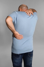 Photo of Mature man suffering from backache on light grey background