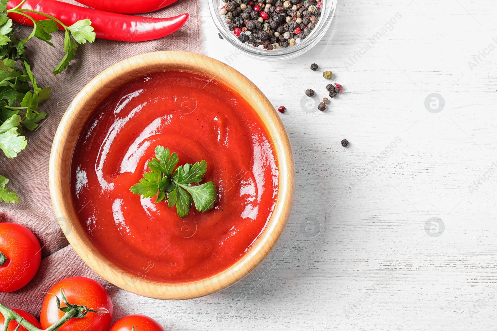 Photo of Flat lay composition with tomato sauce on white wooden table, space for text