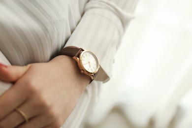 Photo of Woman wearing luxury wristwatch indoors, closeup of hand