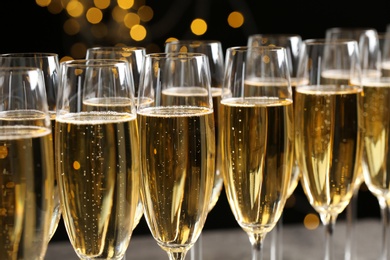 Photo of Many glasses of champagne on blurred background, closeup