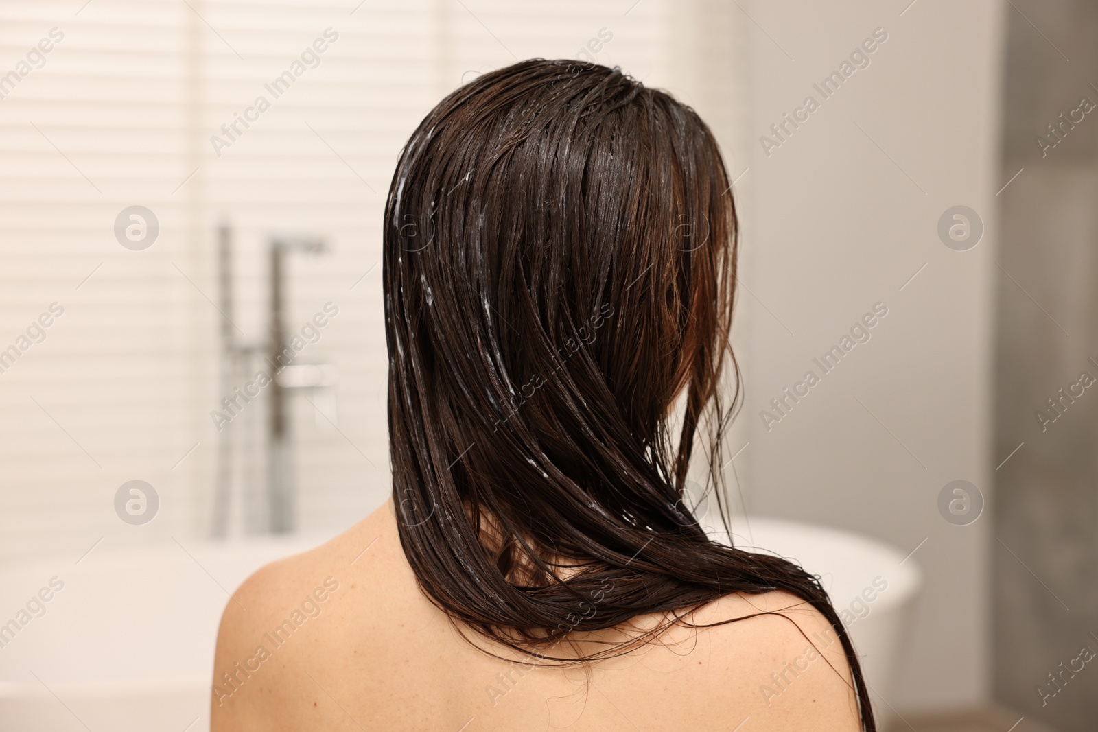 Photo of Woman with hair mask in bathroom, back view