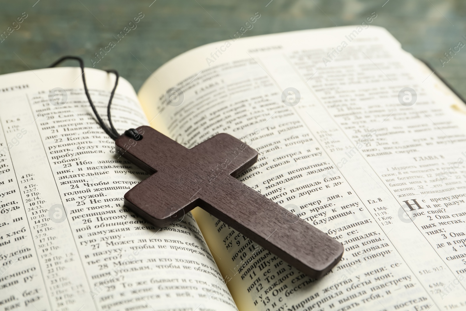 Photo of MYKOLAIV, UKRAINE - DECEMBER 20, 2021: Christian cross and Bible on table, closeup