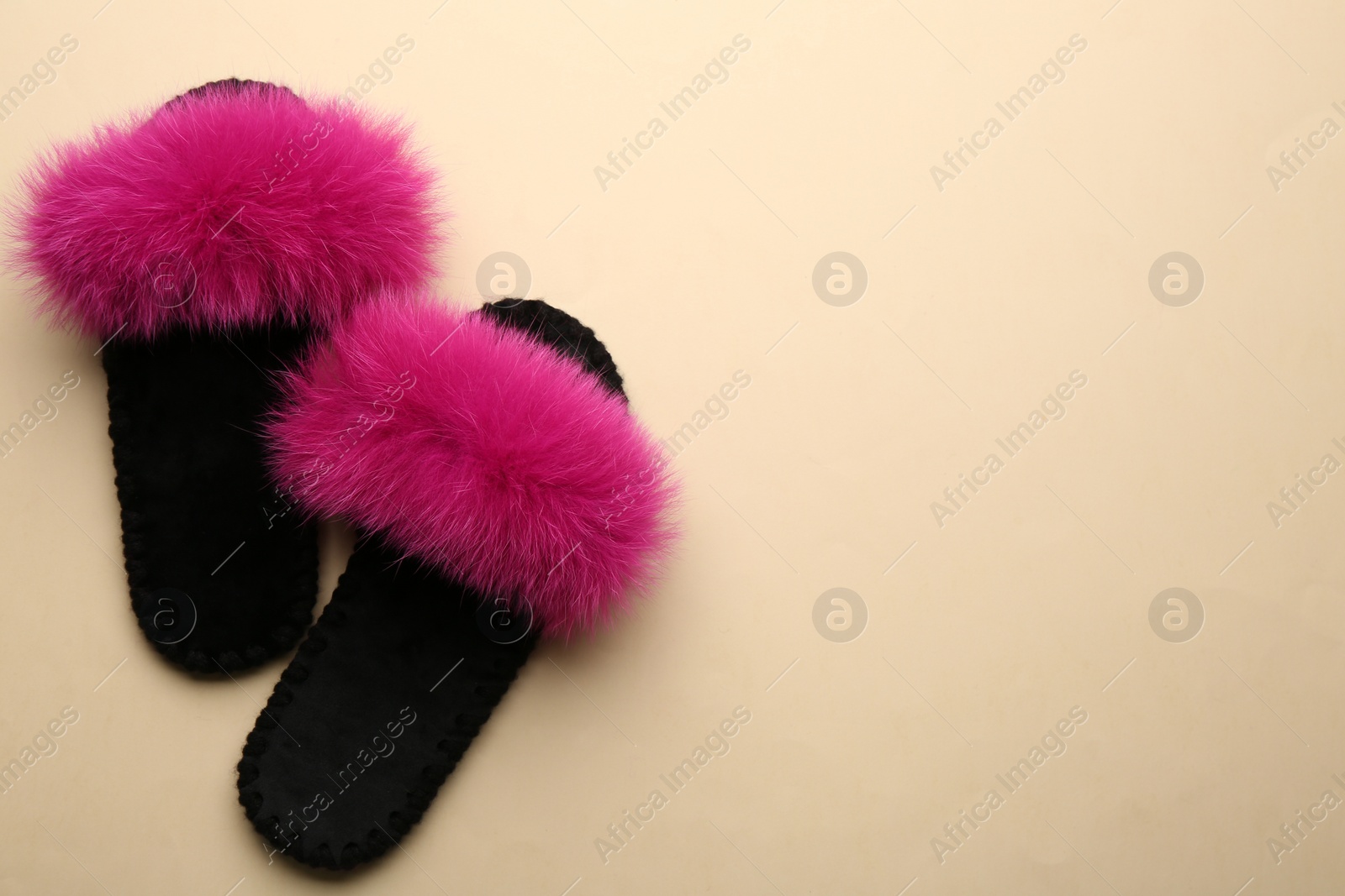 Photo of Pair of soft slippers on beige background, flat lay. Space for text