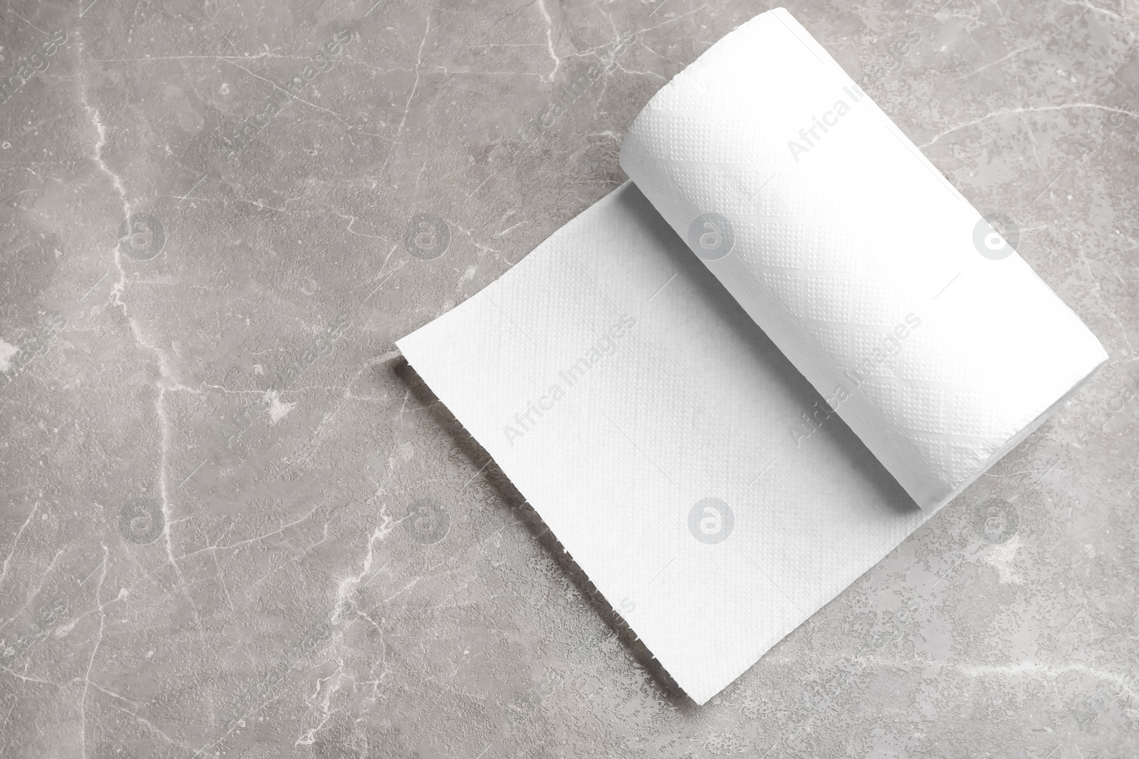 Photo of Roll of paper towels on marble table, top view