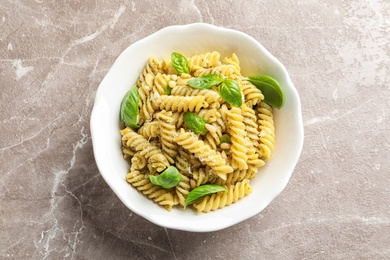 Photo of Plate of delicious basil pesto pasta on table, top view