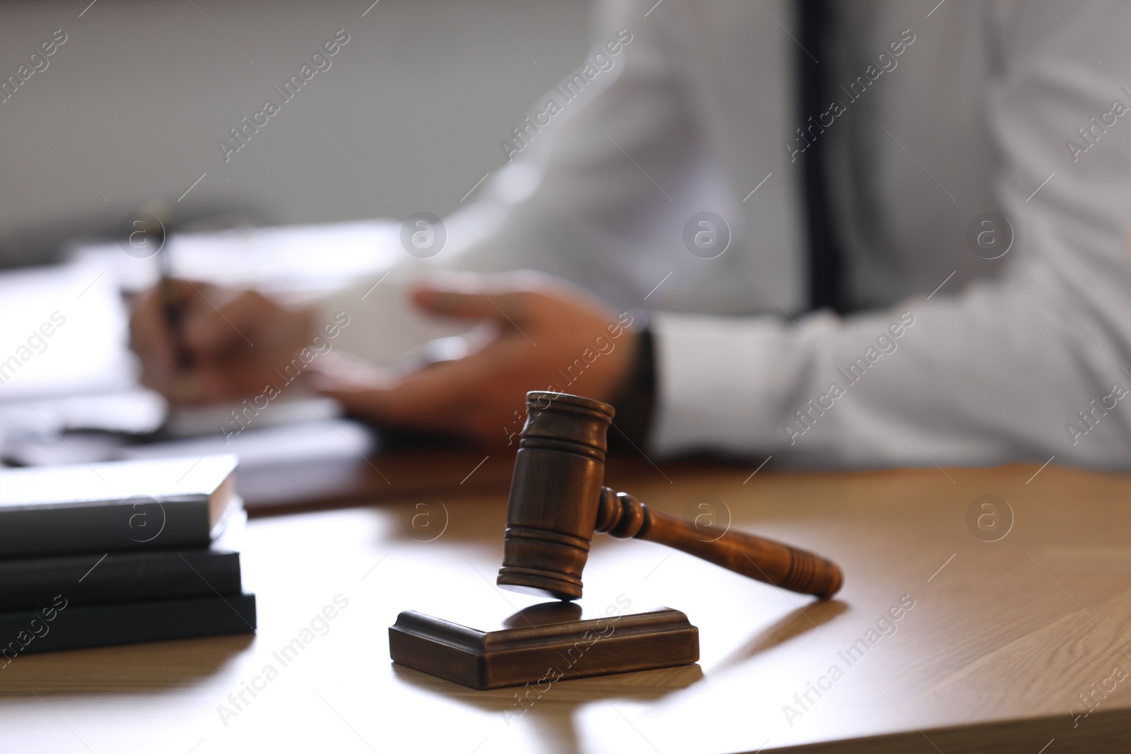 Photo of Male lawyer working at table in office, focus on gavel