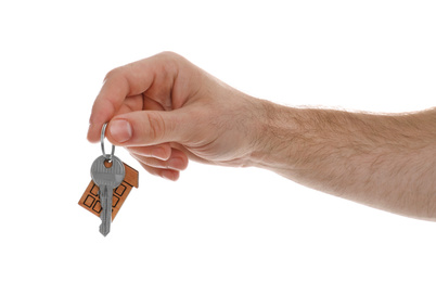 Photo of Real estate agent holding house key with trinket on white background, closeup