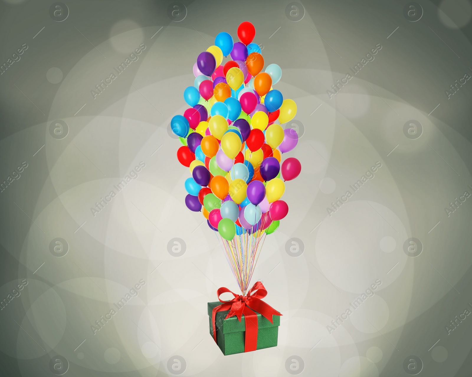 Image of Many balloons tied to gift box on color background