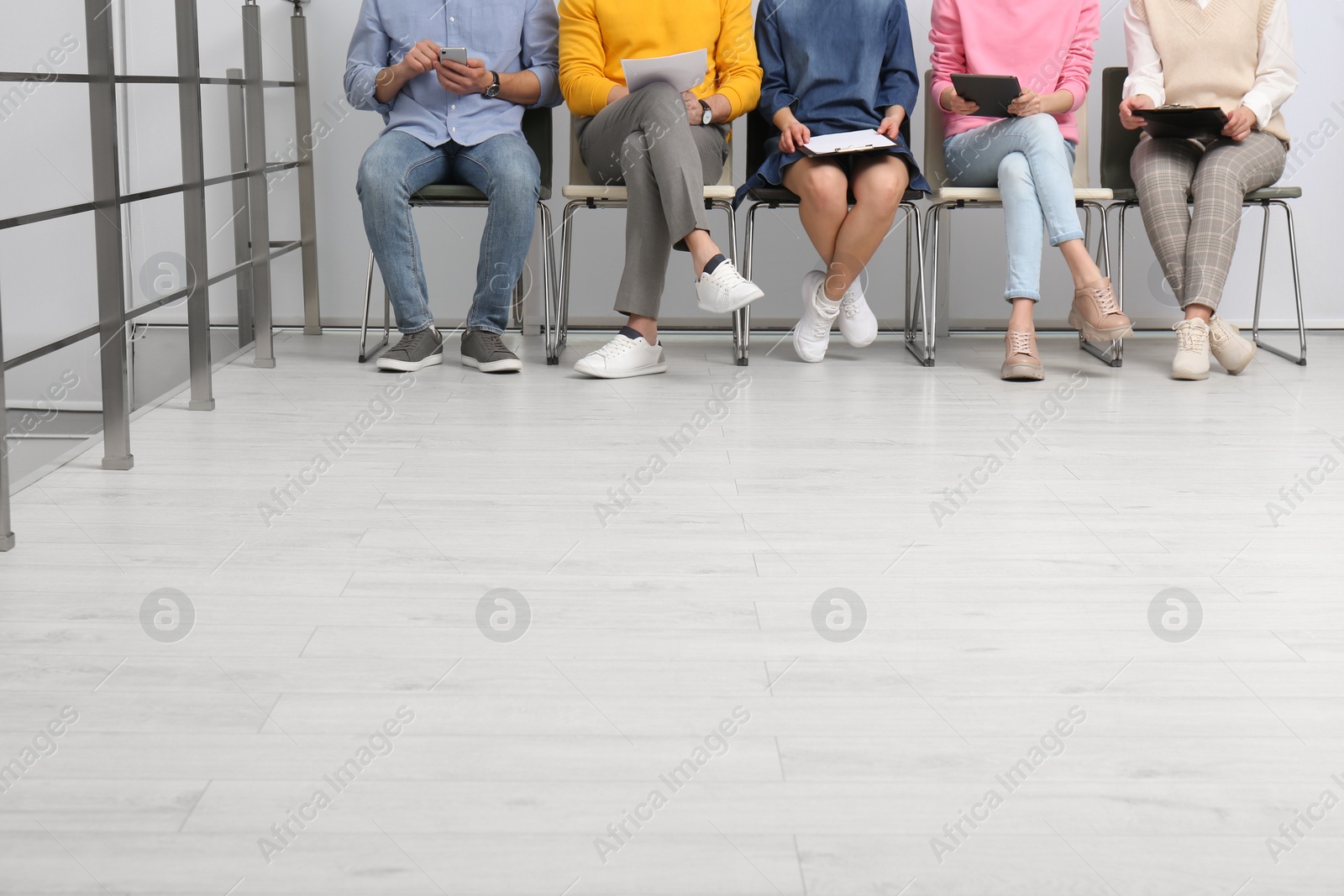 Photo of People waiting for job interview in office hall, closeup