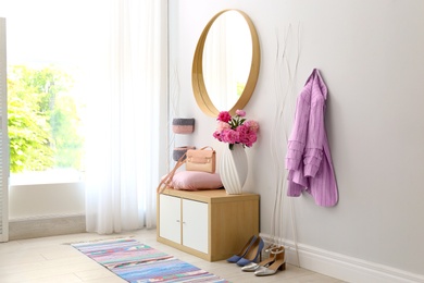 Photo of Stylish hallway interior with round mirror on white wall