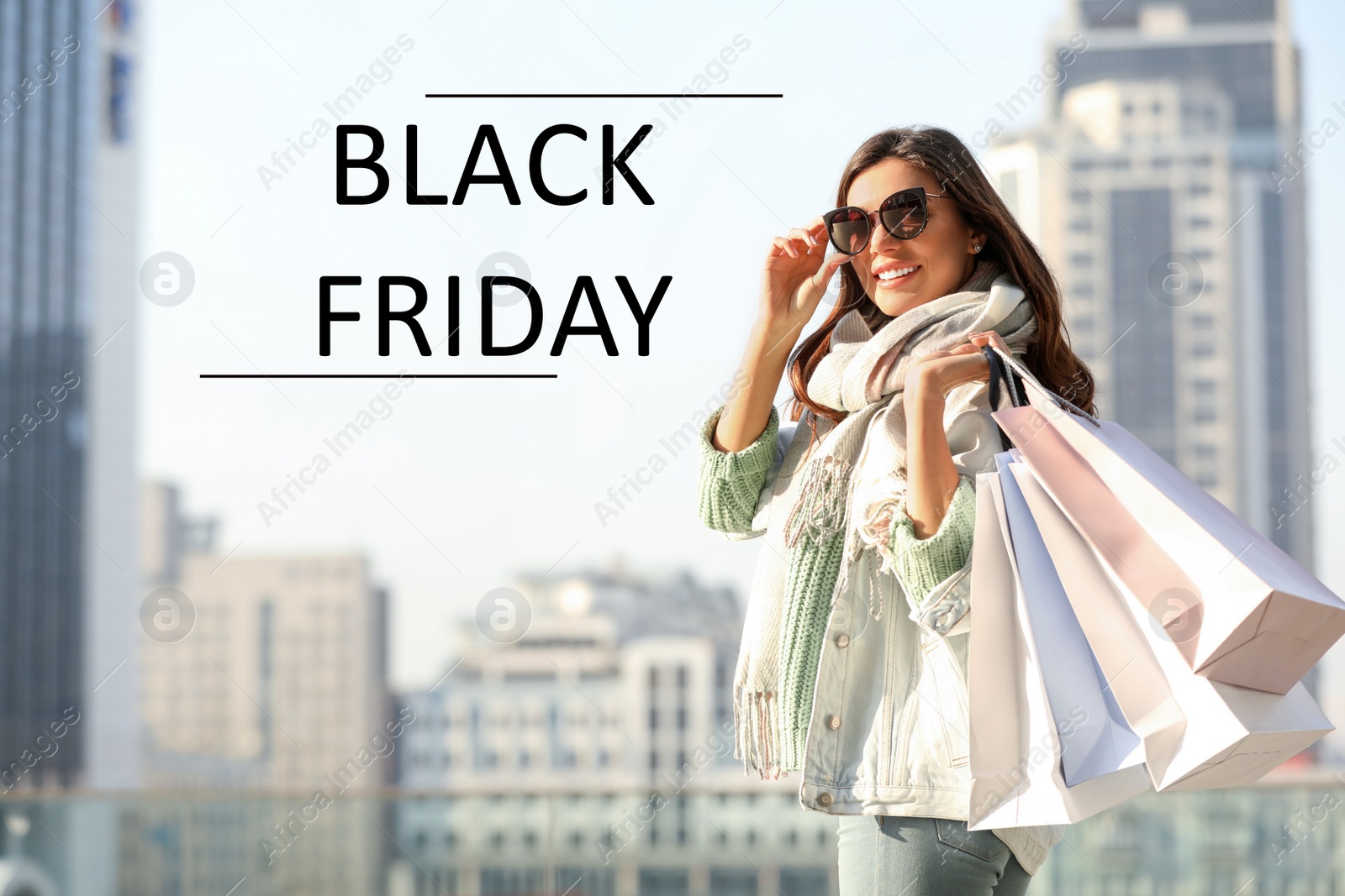 Image of Beautiful young woman with shopping bags on city street. Black Friday Sale