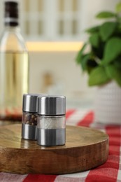 Metal salt and pepper shakers on table indoors, space for text