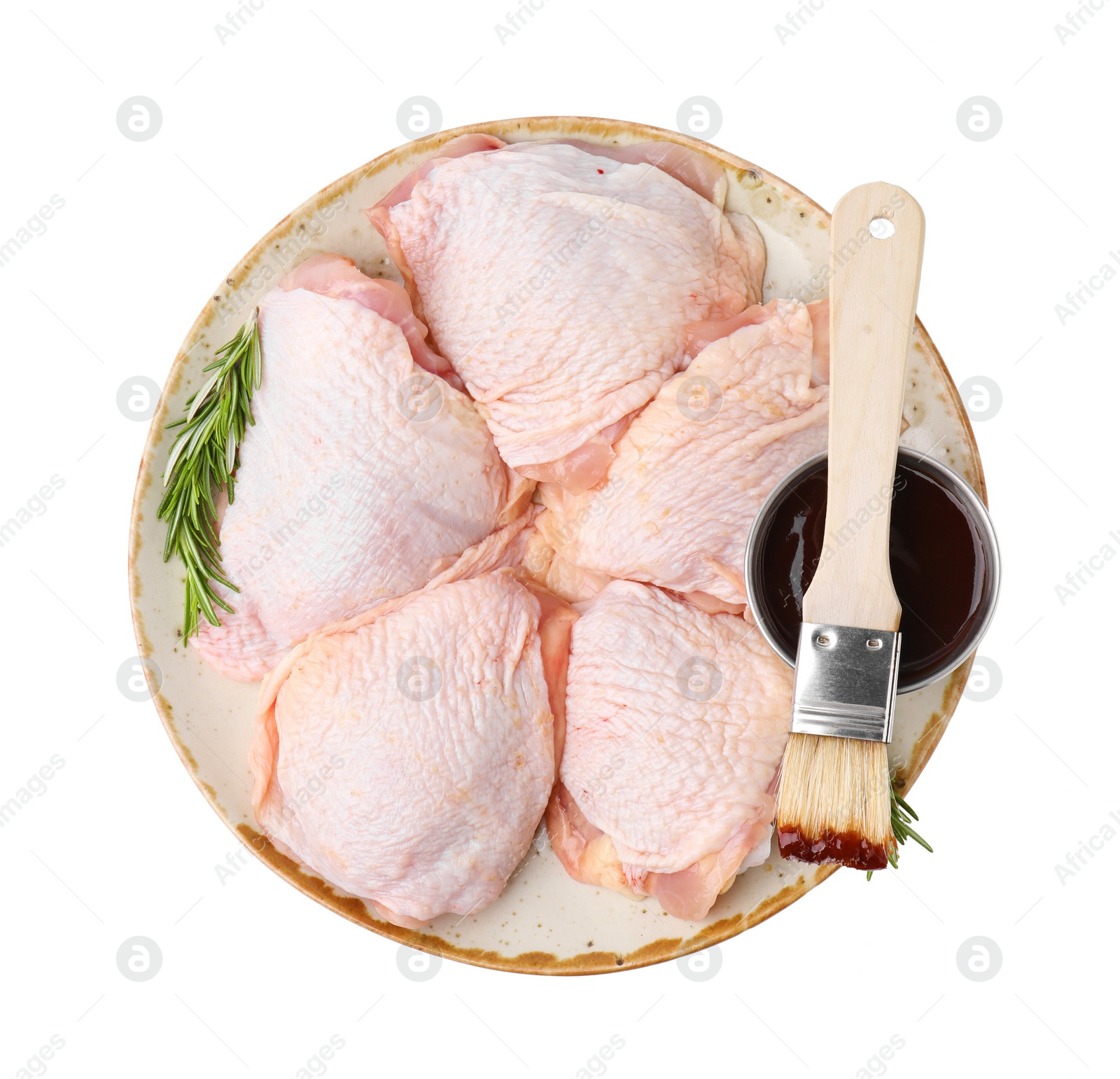 Photo of Plate with marinade, basting brush, raw chicken and rosemary isolated on white, top view