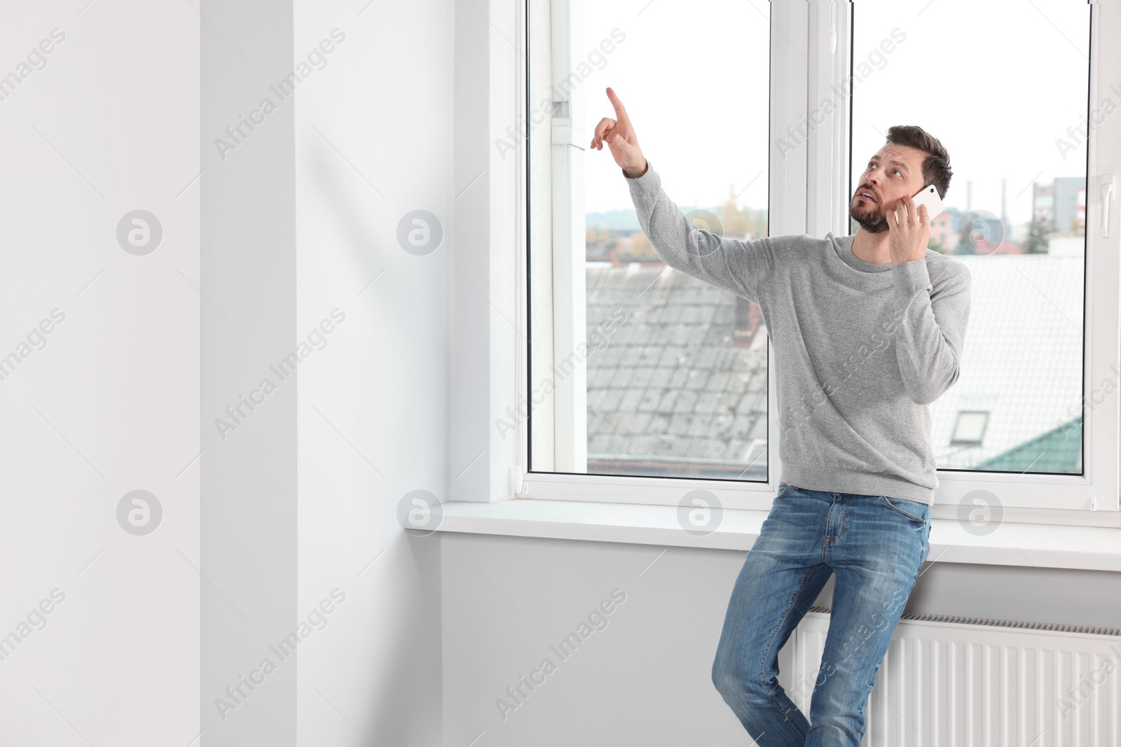 Photo of Man talking on phone near window indoors, space for text