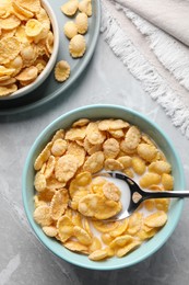 Photo of Tasty cornflakes with milk served on light grey table, flat lay